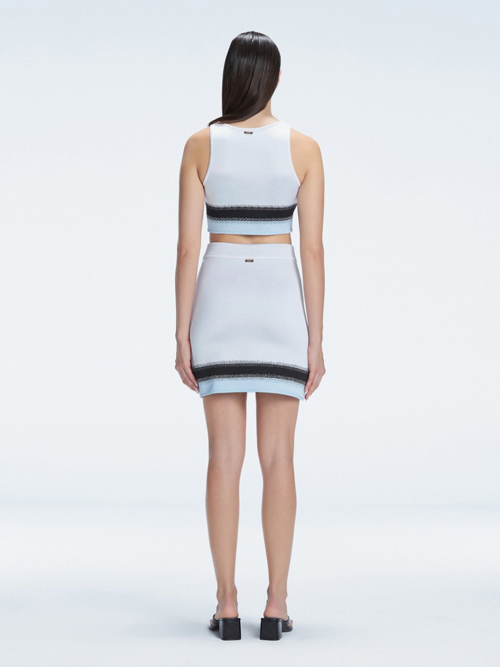 Lydia White Optical Knit Mini Skirt | Moeva | Skirt | Each week unveils new pieces—luxury swimwear, fluid resort silhouettes, and elevated summer-to-evening essentials designed to carry you from coastal escapes to city nights.