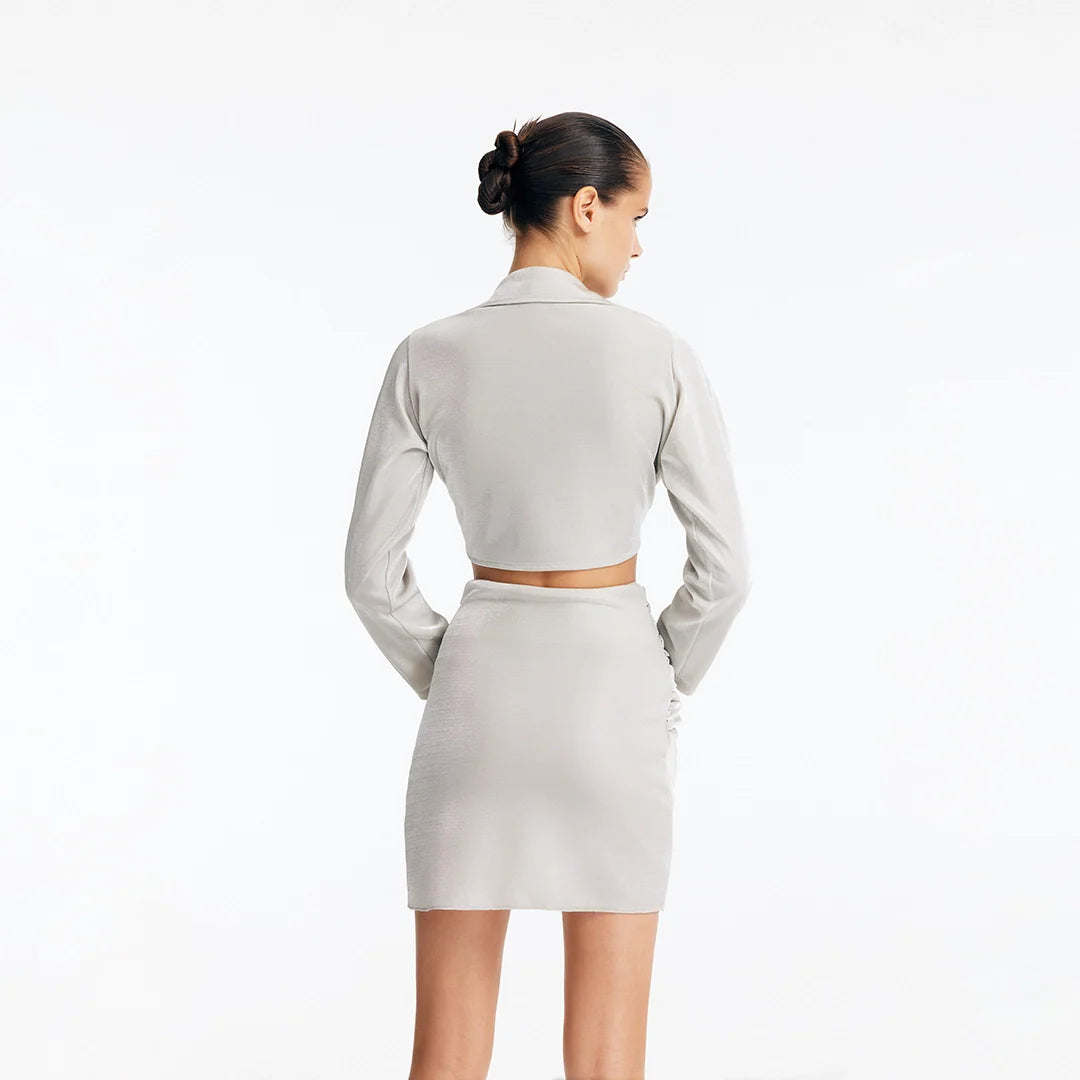 Greta Silver Long Sleeve Tie Front Shirt and Indigo Asymmetric Ring-Drape Mini Skirt | Moeva | Set | Each week unveils new pieces—luxury swimwear, fluid resort silhouettes, and elevated summer-to-evening essentials designed to carry you from coastal escapes to city nights.